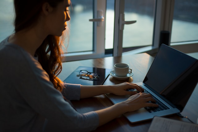 woman is typing on a laptop